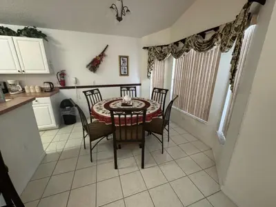 a dining room table and chairs in a kitchen at Cumbrian Sunset Villa home in Kissimmee