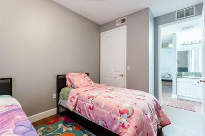 a bedroom with a bed with a pink comforter at Royal Homes in Kissimmee
