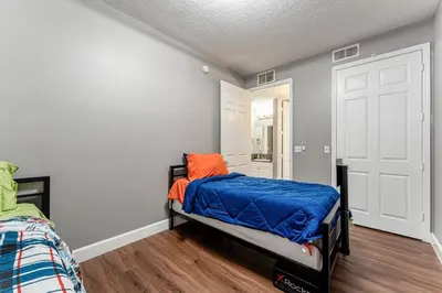 a bedroom with a bed with an orange pillow on it at Royal Homes in Kissimmee