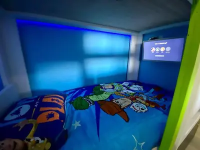 a bedroom with a blue bed with a cartoon bed sqor at Wands & Wishes | Luxury Condo Minutes from Disney in Orlando