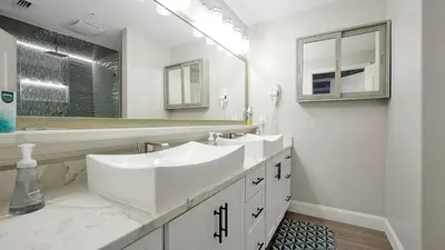 a white bathroom with two sinks and a mirror at Wands & Wishes | Luxury Condo Minutes from Disney in Orlando