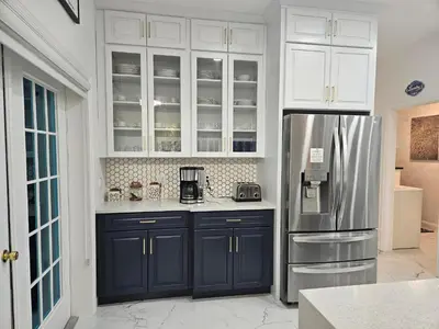 a kitchen with blue cabinets and a refrigerator at Charming, beautiful house closer to Disney World in Orlando