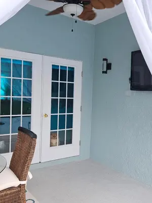 a room with a chair and a window and a tv at Charming, beautiful house closer to Disney World in Orlando