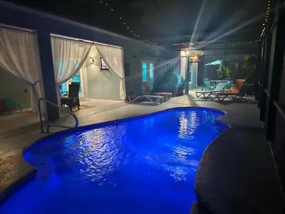 a swimming pool with blue lighting in a house at Charming, beautiful house closer to Disney World in Orlando
