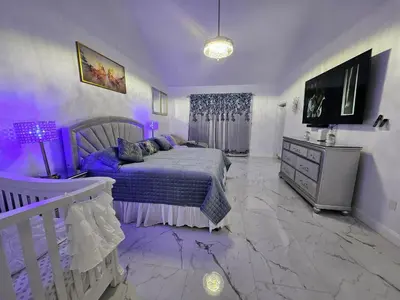 a purple bedroom with a bed and a tv at Charming, beautiful house closer to Disney World in Orlando