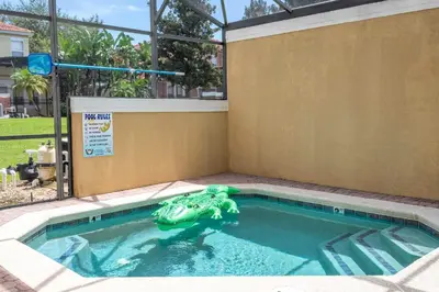 a toyigator in a swimming pool in a house at Bright 3B w Pool Close to Disney Encantada 8545 in Kissimmee