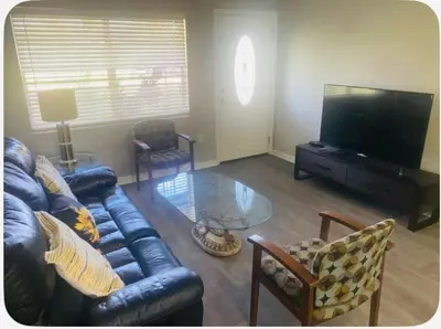 a living room with a leather couch and a glass table at Entire 5 Bedroom Home in Winter Park FL in Orlando
