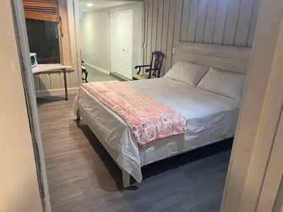 a bedroom with a bed and a chair and a window at Entire 5 Bedroom Home in Winter Park FL in Orlando