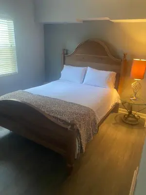 a bedroom with a large bed with a wooden headboard at Entire 5 Bedroom Home in Winter Park FL in Orlando