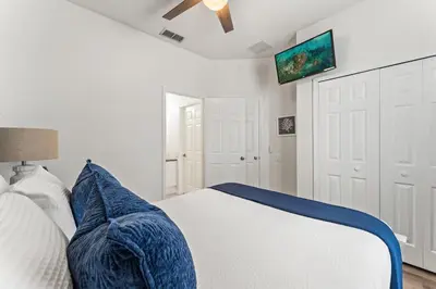 a bedroom with a bed and a ceiling fan at Magical Stay Near Disney I Pool and Resort Access in Kissimmee