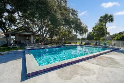 a large swimming pool with blue water in a yard at Spacious 2BR Condo Near Disney with Pool & Basketball in Kissimmee