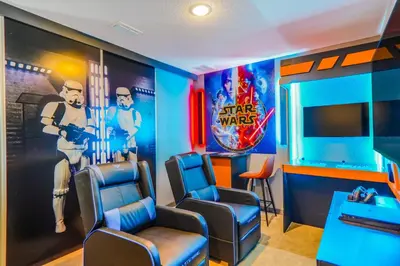 a waiting room with chairs and a movie poster at 3 Bedroom 8 Miles from Disney Word in Kissimmee