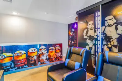a room with two chairs and a movie room with incredibles mural at 3 Bedroom 8 Miles from Disney Word in Kissimmee