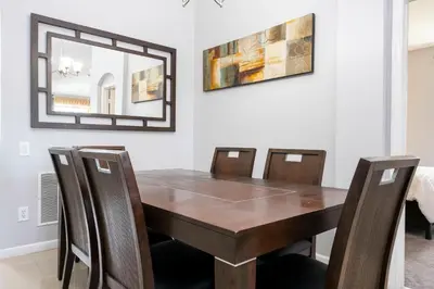a dining room table with chairs and a mirror at Game Room 4 BD Private Pool BBQ 2252 in Kissimmee