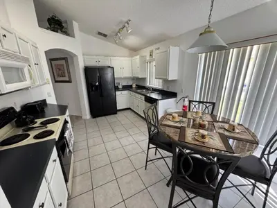 a kitchen with a table and a black refrigerator at Ortega Villa home in Kissimmee
