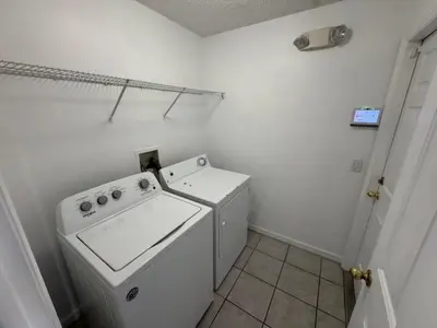 a small white laundry room with a washer and dryer at Ortega Villa home in Kissimmee