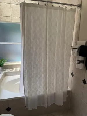 a white shower curtain in a bathroom with a tub at 3 bedroom home with private pool in Orlando