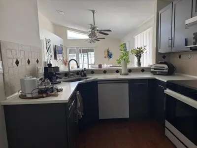 a kitchen with black cabinets and a ceiling fan at 3 bedroom home with private pool in Orlando