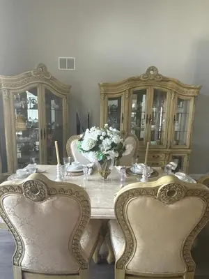 a dining room table with two chairs and a vase of flowers at Cozy family house near Disney,epic and universal in Orlando