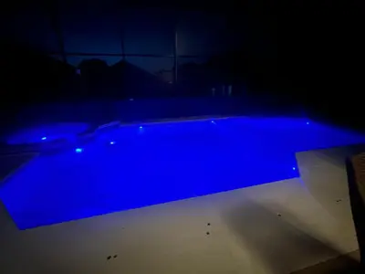 a blue swimming pool in a dark room at Cozy family house near Disney,epic and universal in Orlando