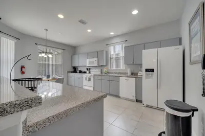 a kitchen with white appliances and a white refrigerator at Disney Getaway Pool Gated Resort Near Parks in Kissimmee