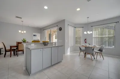 a kitchen and dining room with a table and chairs at Disney Getaway Pool Gated Resort Near Parks in Kissimmee