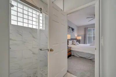 a bathroom with a walk in shower next to a bedroom at Disney Getaway Pool Gated Resort Near Parks in Kissimmee