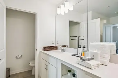 a white bathroom with a sink and a mirror at Condo Luxo 3 Quartos | Storey Lake Resort in Kissimmee