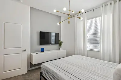 a bedroom with a bed and a tv on a wall at Condo Luxo 3 Quartos | Storey Lake Resort in Kissimmee
