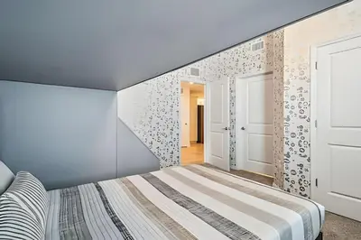 a bedroom with a bed and a wall with patterns at Condo Luxo 3 Quartos | Storey Lake Resort in Kissimmee