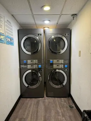 two washing machines are in a laundry room at Apartamento Moderno 2 Quartos The Enclave in Orlando