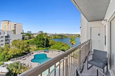 a balcony with a view of a pool and a body of water at Apartamento Moderno 2 Quartos The Enclave in Orlando