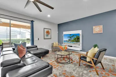 a living room with a couch and a tv at Neverland Nook in Orlando