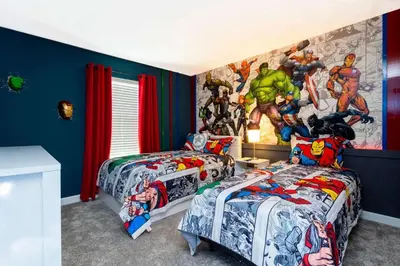 a bedroom with two beds and a marvel mural at Townhouse Moderna 4Q c/ Piscina /10 Min da Disney! in Kissimmee