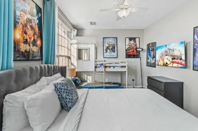 a bedroom with a bed with posters on the wall at Elegante Casa 3 Quartos no Vista Cay in Orlando