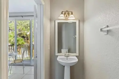 a bathroom with a sink and a mirror at Elegante Casa 3 Quartos no Vista Cay in Orlando