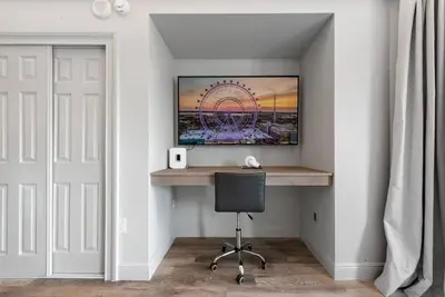 a computer desk in a room with a ferris wheel at Estúdio The Enclave – Piscinas, academia e vista in Orlando