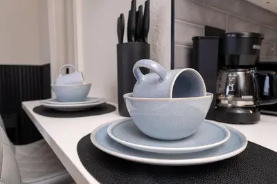 a kitchen counter with two bowls and plates on it at Estúdio The Enclave – Piscinas, academia e vista in Orlando