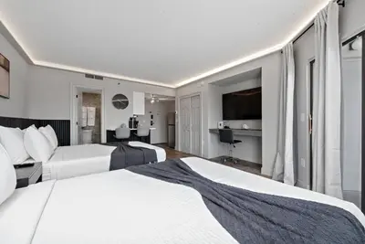 a hotel room with two beds and a television at Estúdio The Enclave – Piscinas, academia e vista in Orlando