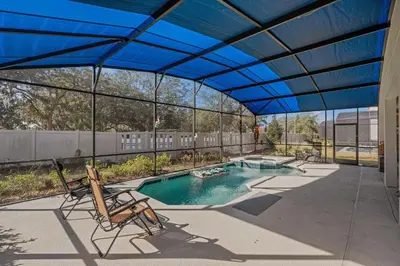 a blue canopy over a swimming pool with chairs at Cozy Rooms In An Elegant House in Kissimmee