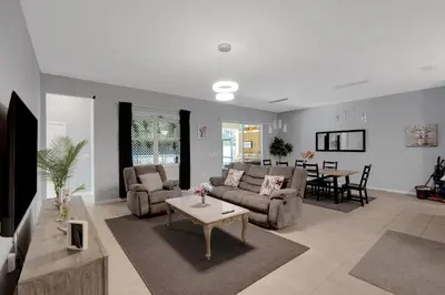a living room with a couch and a table at Cozy Rooms In An Elegant House in Kissimmee