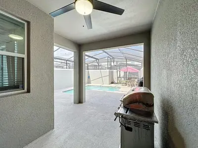 a ceiling fan in a room with a pool at Luxury Pool Home Near Disney Resort Access in Kissimmee