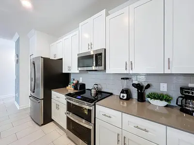 a kitchen with white cabinets and stainless steel appliances at Luxury Pool Home Near Disney Resort Access in Kissimmee