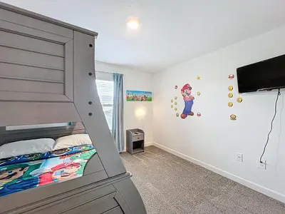 a bedroom with a bunk bed and a tv at Luxury Pool Home Near Disney Resort Access in Kissimmee