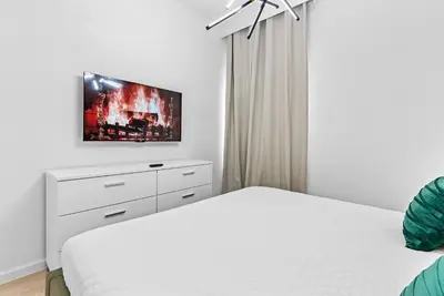 a white bedroom with two beds and a tv on the wall at 2026 Luxury 5Bedrooms At Paradiso Grande in Orlando
