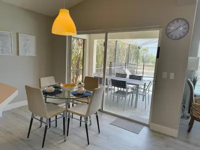 a dining room with a table and chairs and a clock at Magnificent View-Close to Disney in Kissimmee