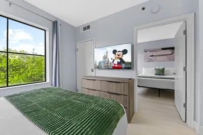 a bedroom with a bed and a large window at Orlando 2BR Apt Full Kitchen Epic Universe in Orlando