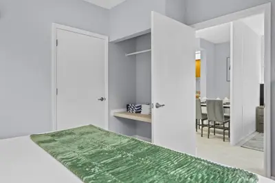 a bedroom with white walls and a green rug at Orlando 2BR Apt Full Kitchen Epic Universe in Orlando