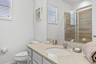 a white bathroom with a sink and a toilet at Pool 4BR Resort Home Near Disney in Kissimmee