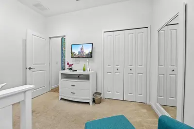 a room with white doors and a desk with a computer at Pool 4BR Resort Home Near Disney in Kissimmee